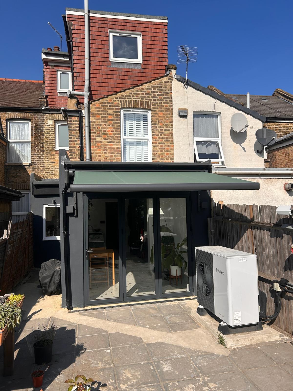 Close up of a powder coated aluminium awning cassette and folding arm joint on brickwork