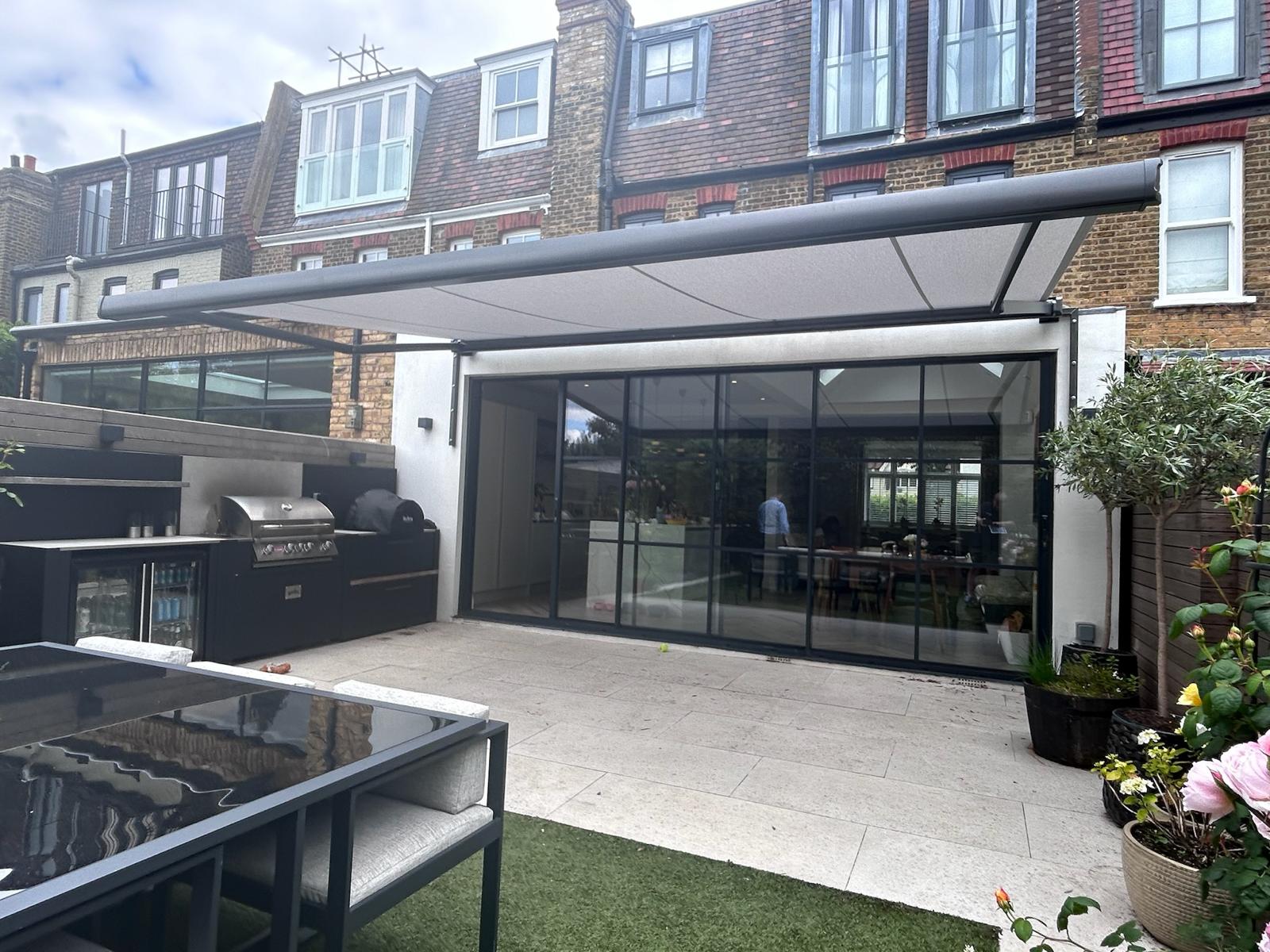 Close up of an aluminium awning housing and folding arm joint mounted on brickwork